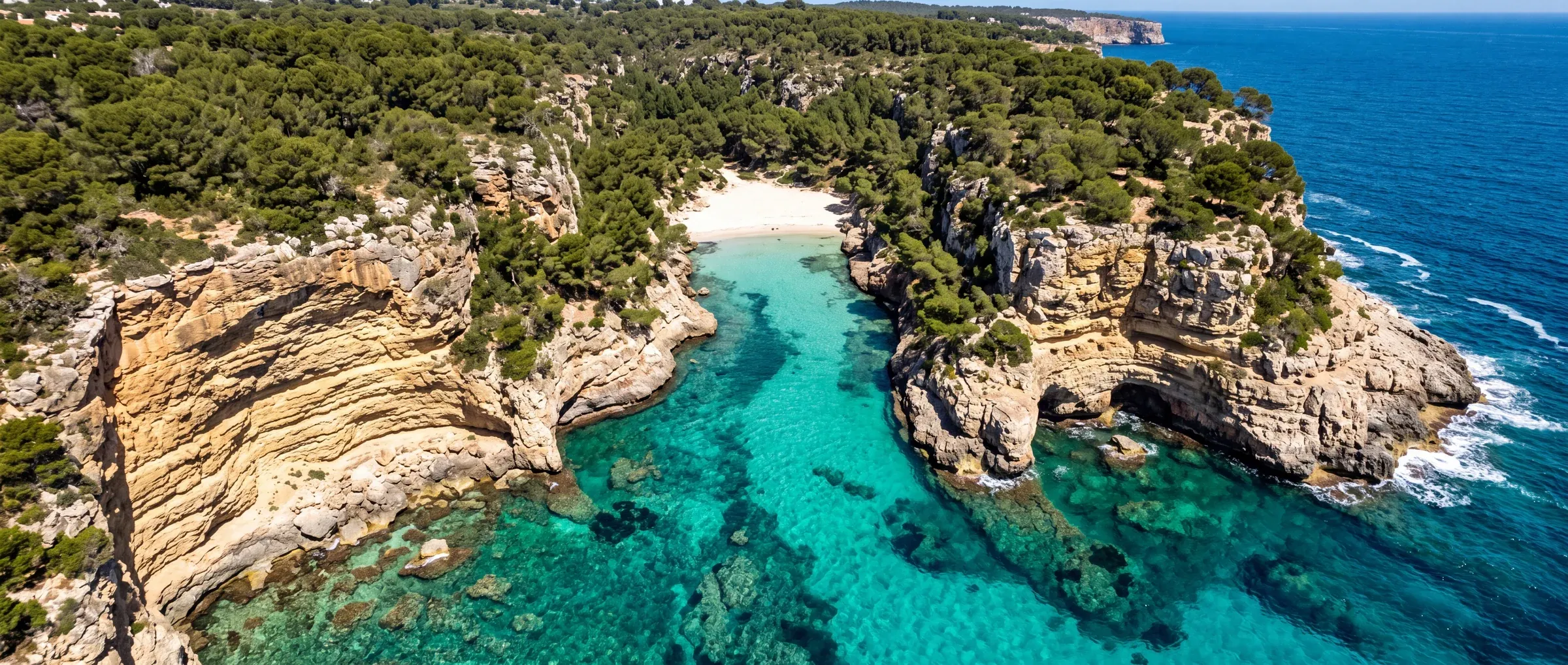 Cala de Santanyí vista desde el aire, agua turquesa entre acantilados de marès